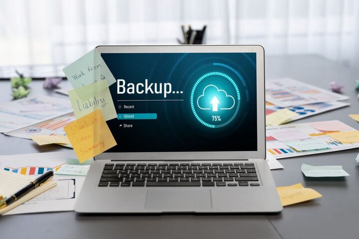 A laptop screen showing a backup window and a cloud.