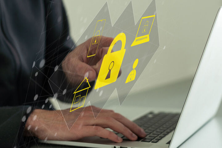 A businessman types on a laptop while a padlock hologram marks the data his AI tools can reach.