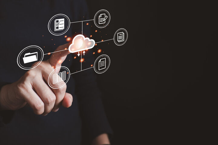 A hand touches a cloud ringed by file and document symbols.