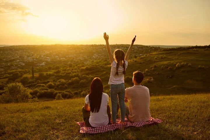 People watching the sunset from a hilltop.