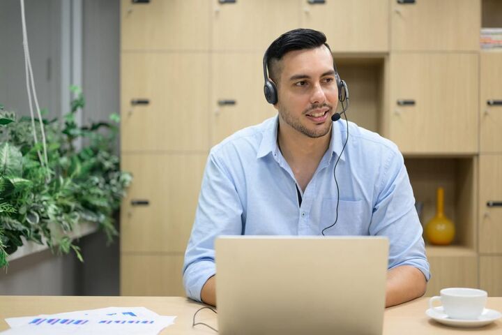 A manager working at a laptop in an open office.