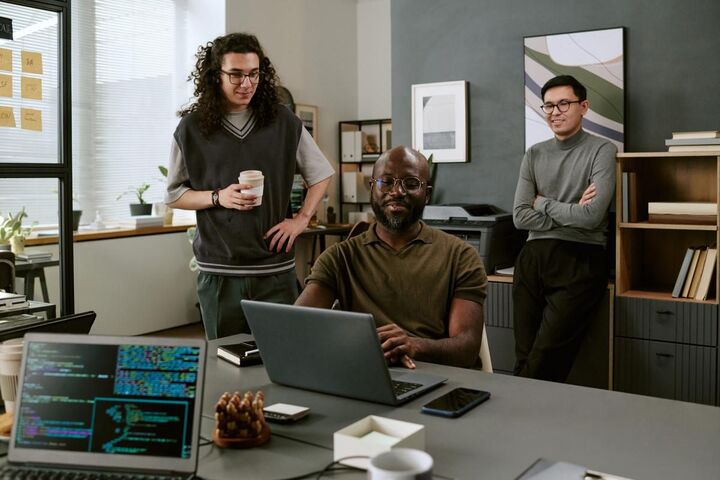 A developer at a laptop with code and charts on screen.
