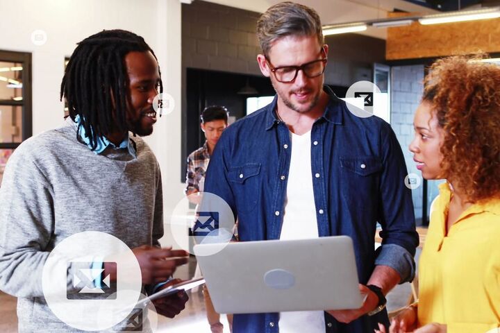 Three colleagues talking around a laptop.