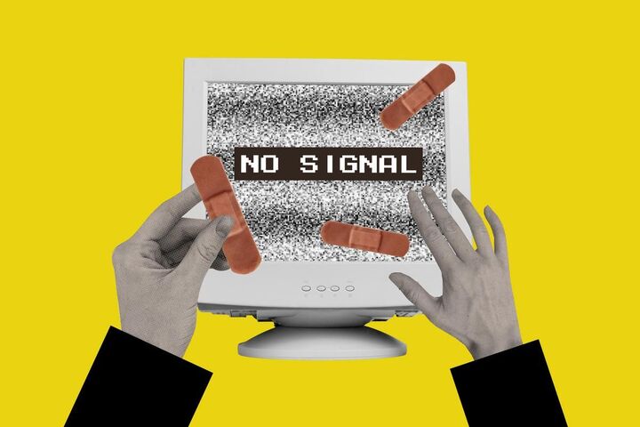 Hands repairing a computer showing a no signal message.