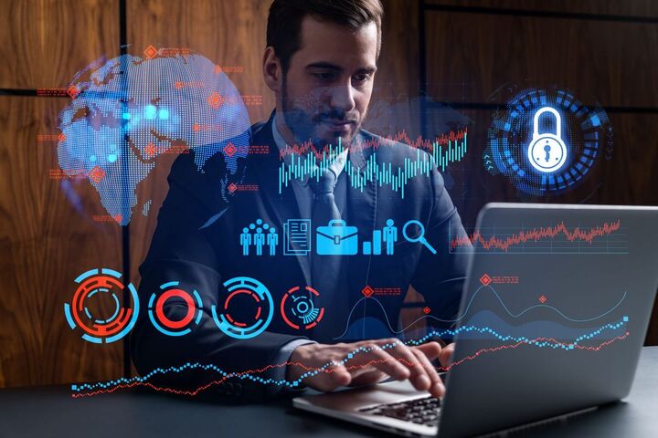 A man at his desk reviewing analytics on a monitor.