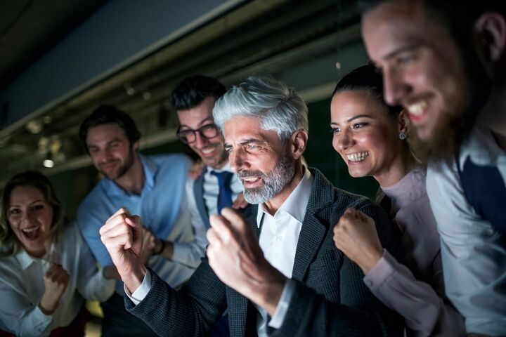 A group of colleagues in conversation in an office.