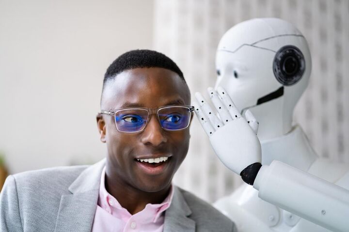 A man shaking hands with a white robot.