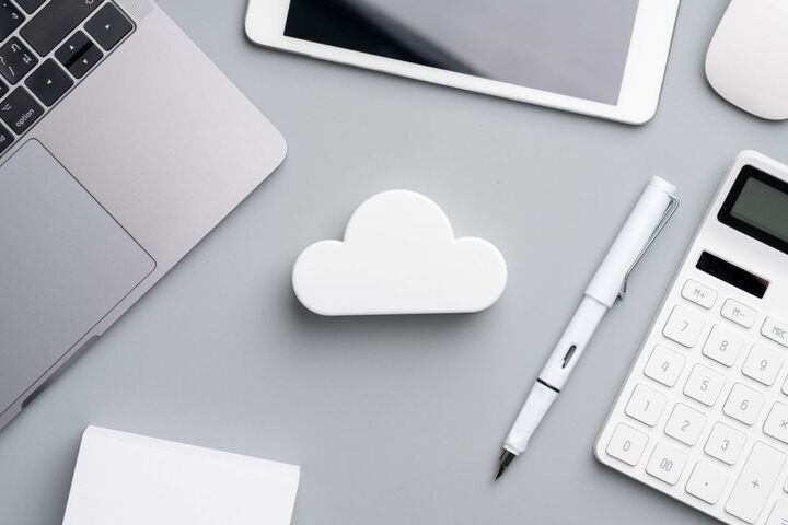 A cloud floating above a laptop keyboard.
