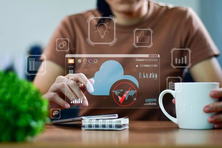 Hands holding a phone in front of a screen of connected device icons.