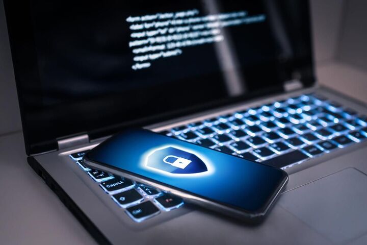 Hands typing on a laptop with a padlock on the screen.
