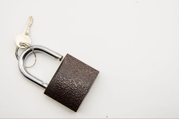 A closed brass padlock on a metal surface.