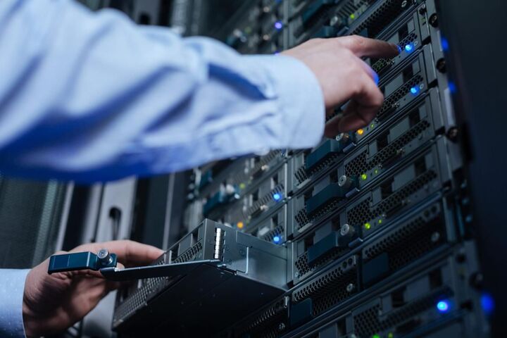 A technician checking a server rack against a tablet.